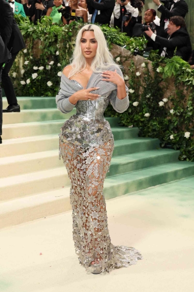 Kim Kardashian wore a gray sweater over a glam sheer metallic gown to the 2024 Met Gala. See her full look, here.